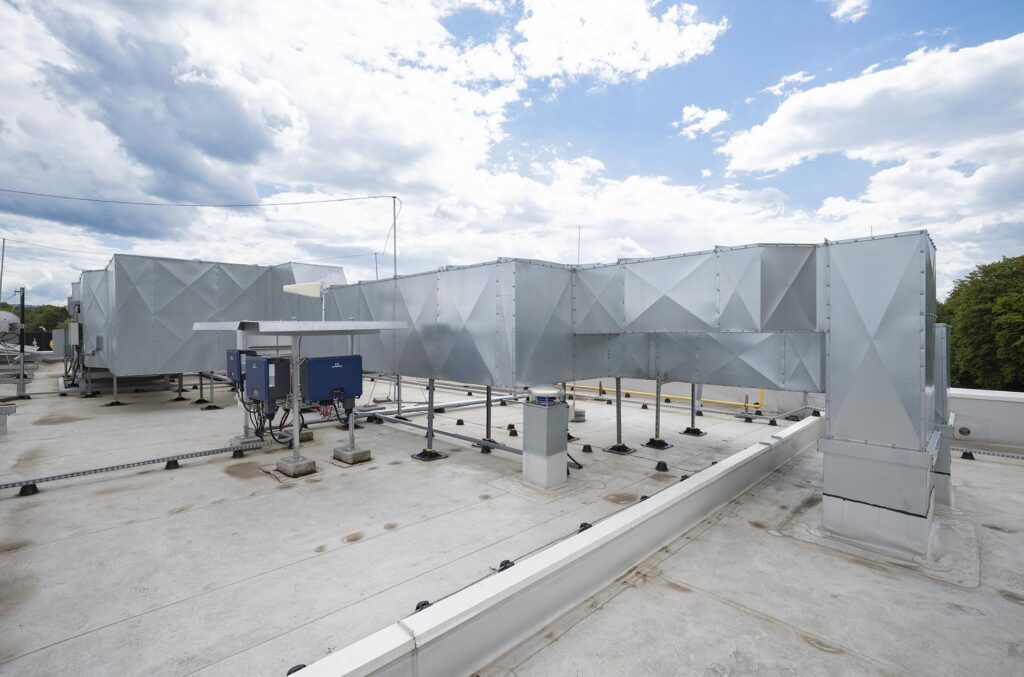 Metalowe kanały wentylacyjne i urządzenia HVAC na płaskim dachu